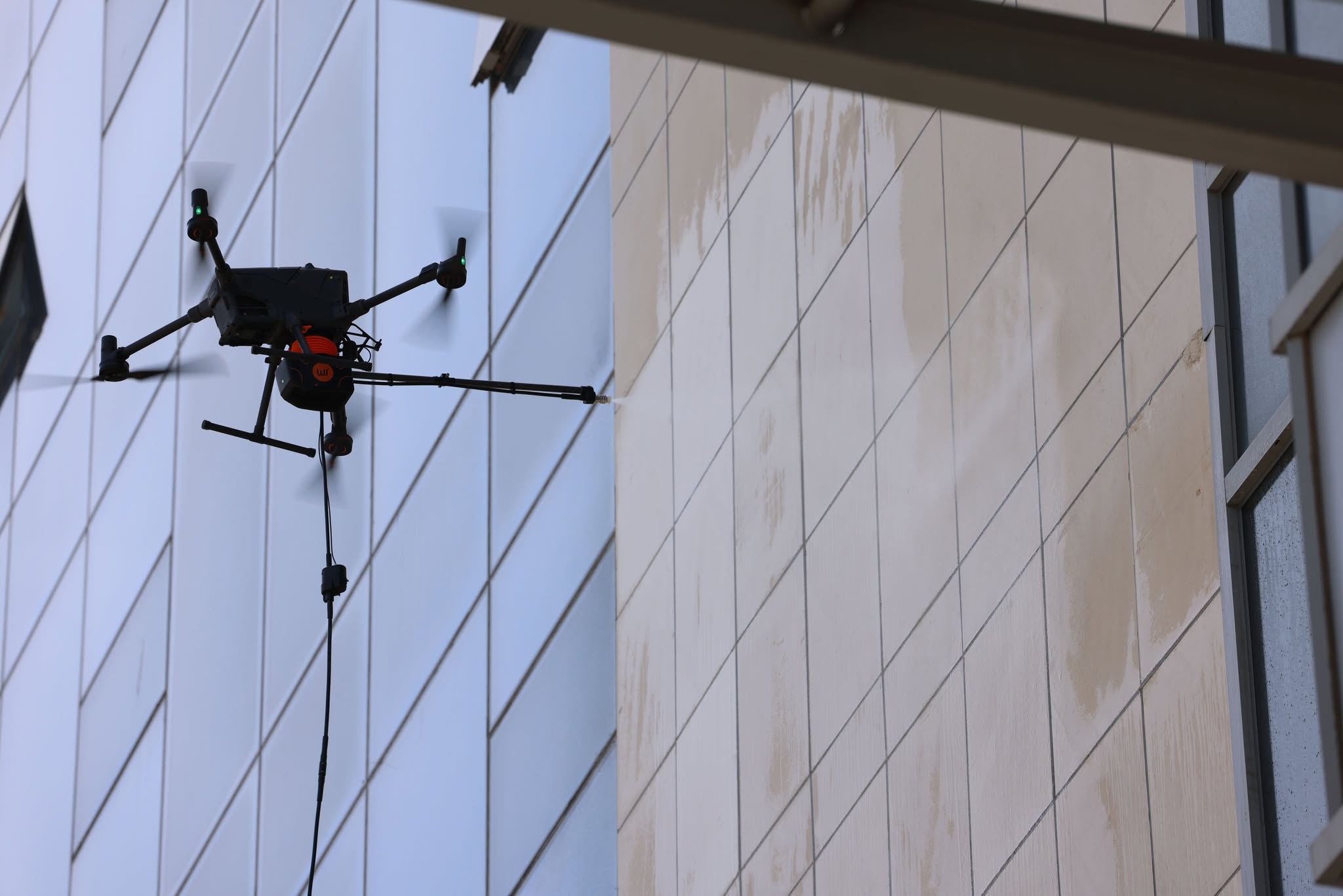 Барилгын гадна фасад, гэрлэн дохиог дрон ашиглан угааж байна